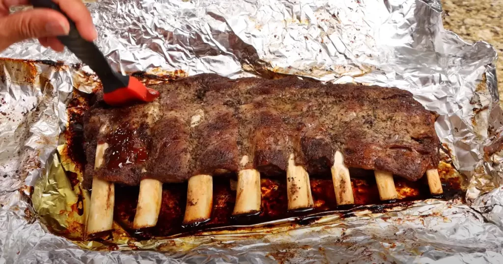 putting bbq sauce on ribs